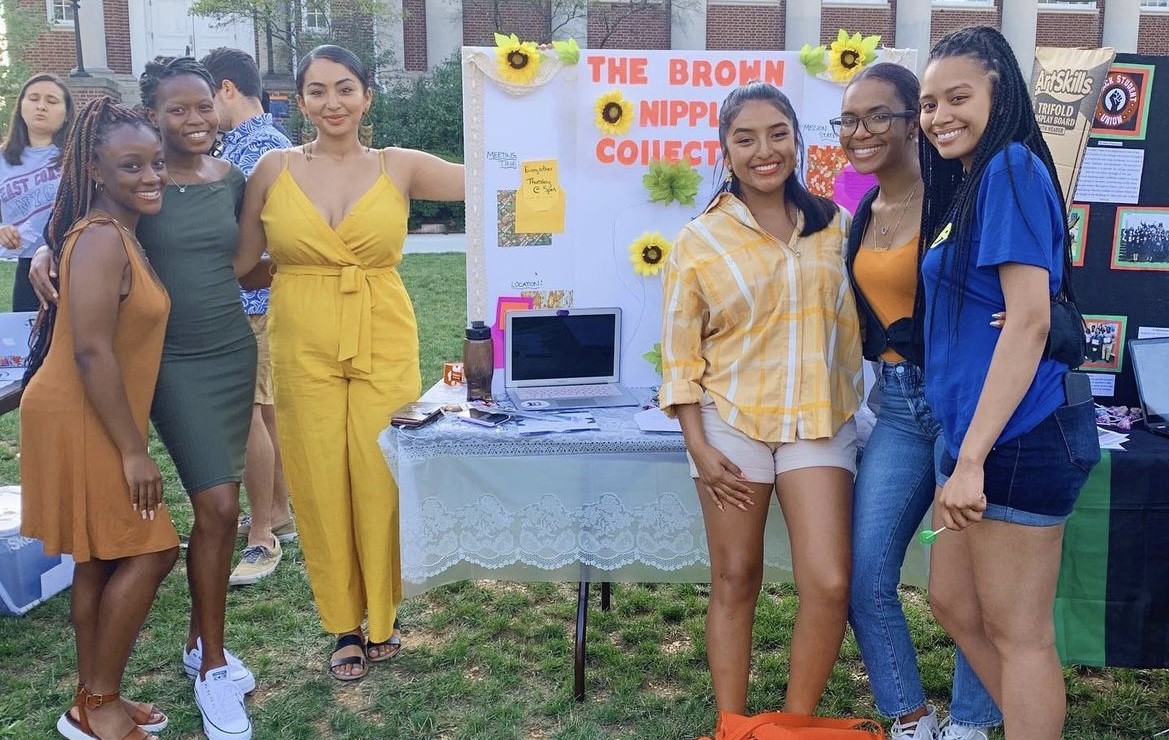 Group of women in front of a board reading "The Brown Nipple Collective."