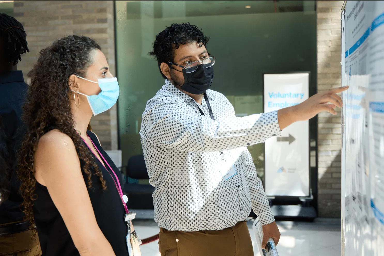 Kevin Medina pointing at his scientific research poster at the Icahn School of Medicine